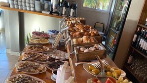 Un buffet de petit-déjeuner proposant un assortiment de viennoiseries, de fruits et de boissons.