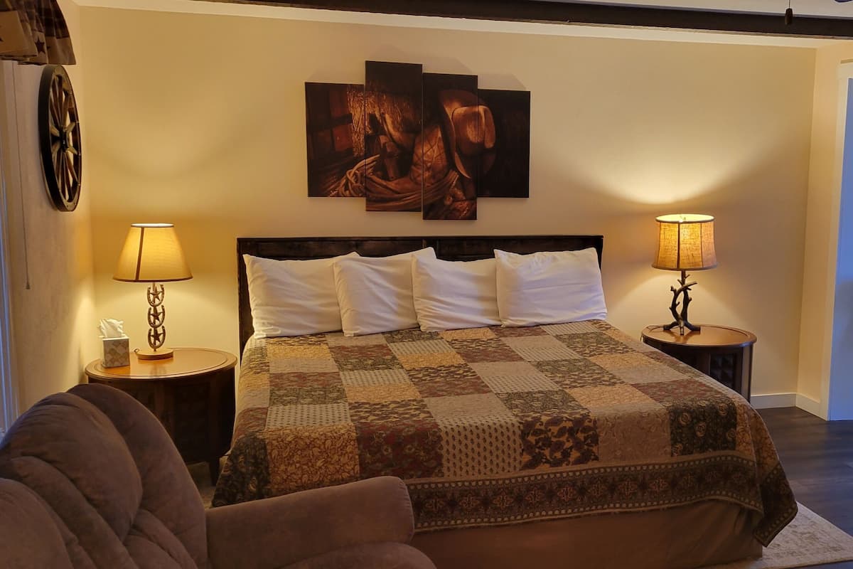 A bedroom with a large bed, two bedside tables with lamps, a star decoration on the wall, and a chair in the corner.