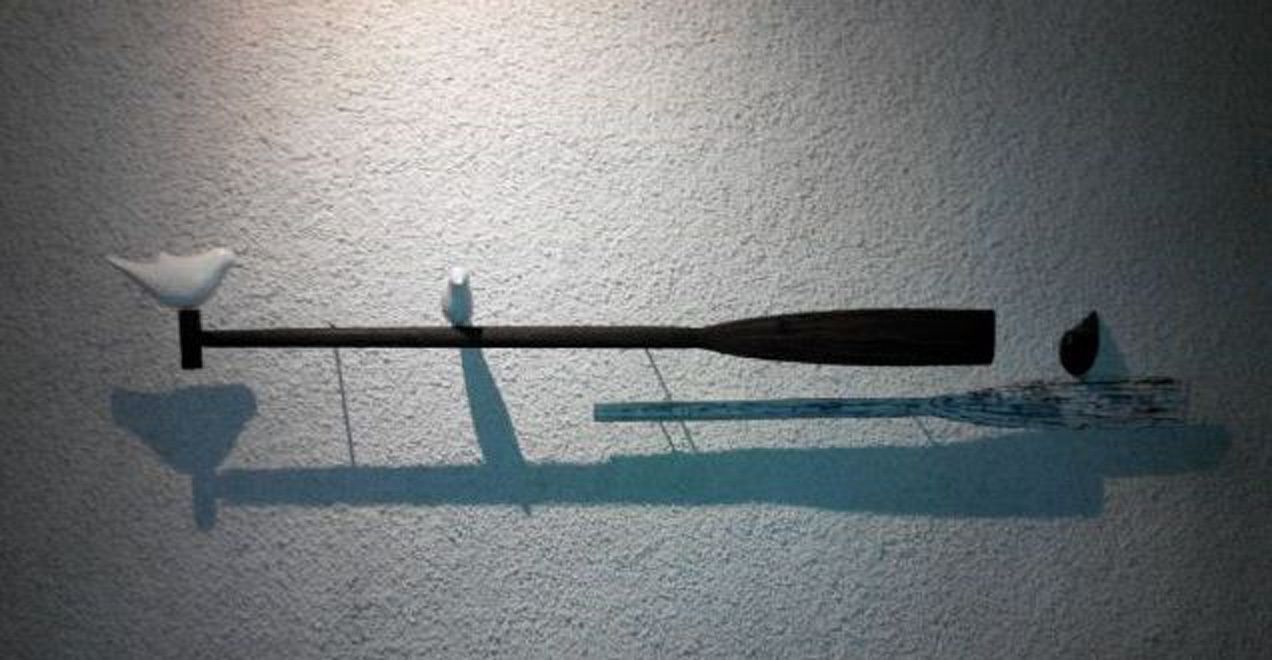 A bat and a bird on a wall.