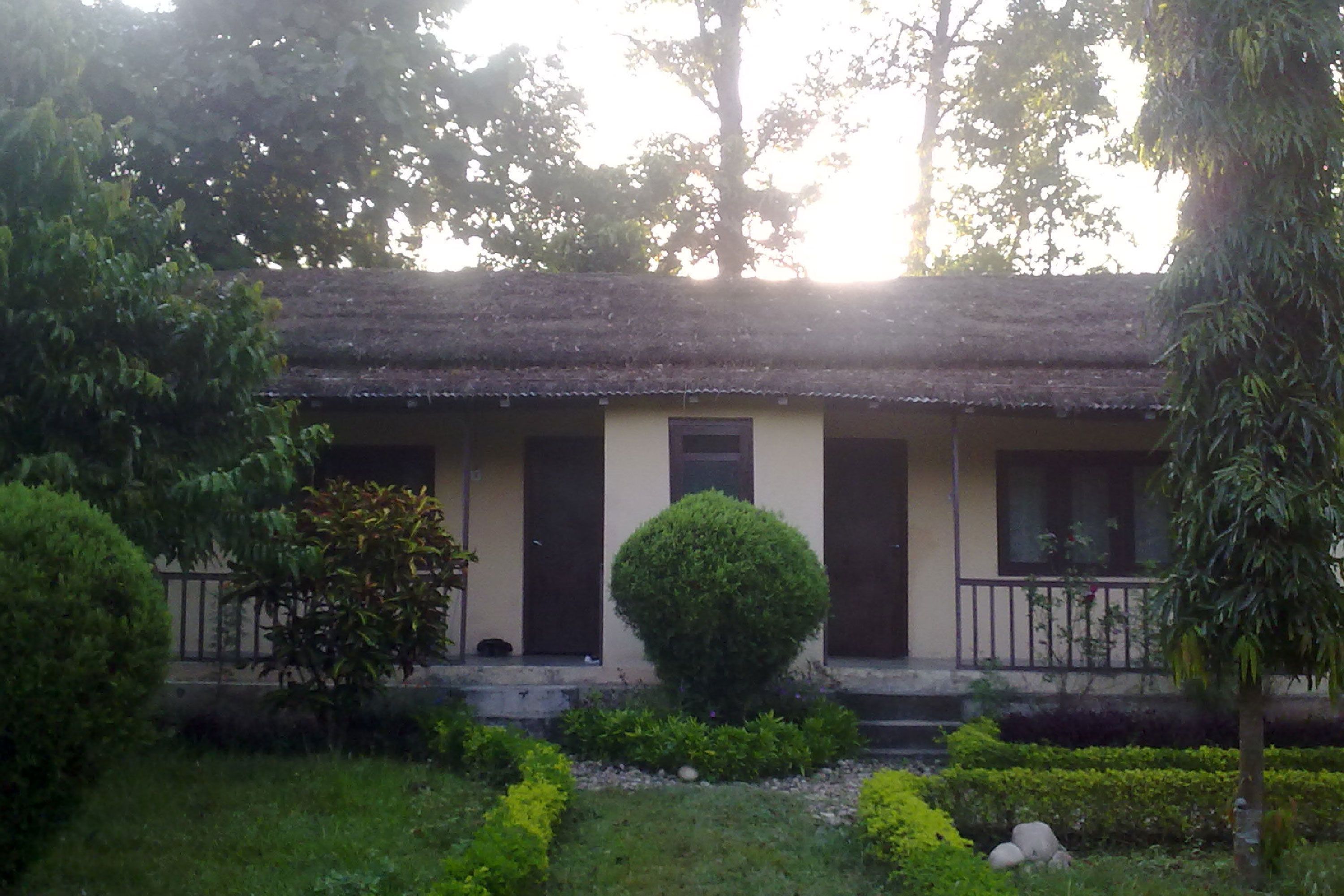 A building with a flat roof, a central door, and a small porch with railings.