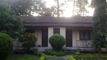 A building with a flat roof, a central door, and a small porch with railings.