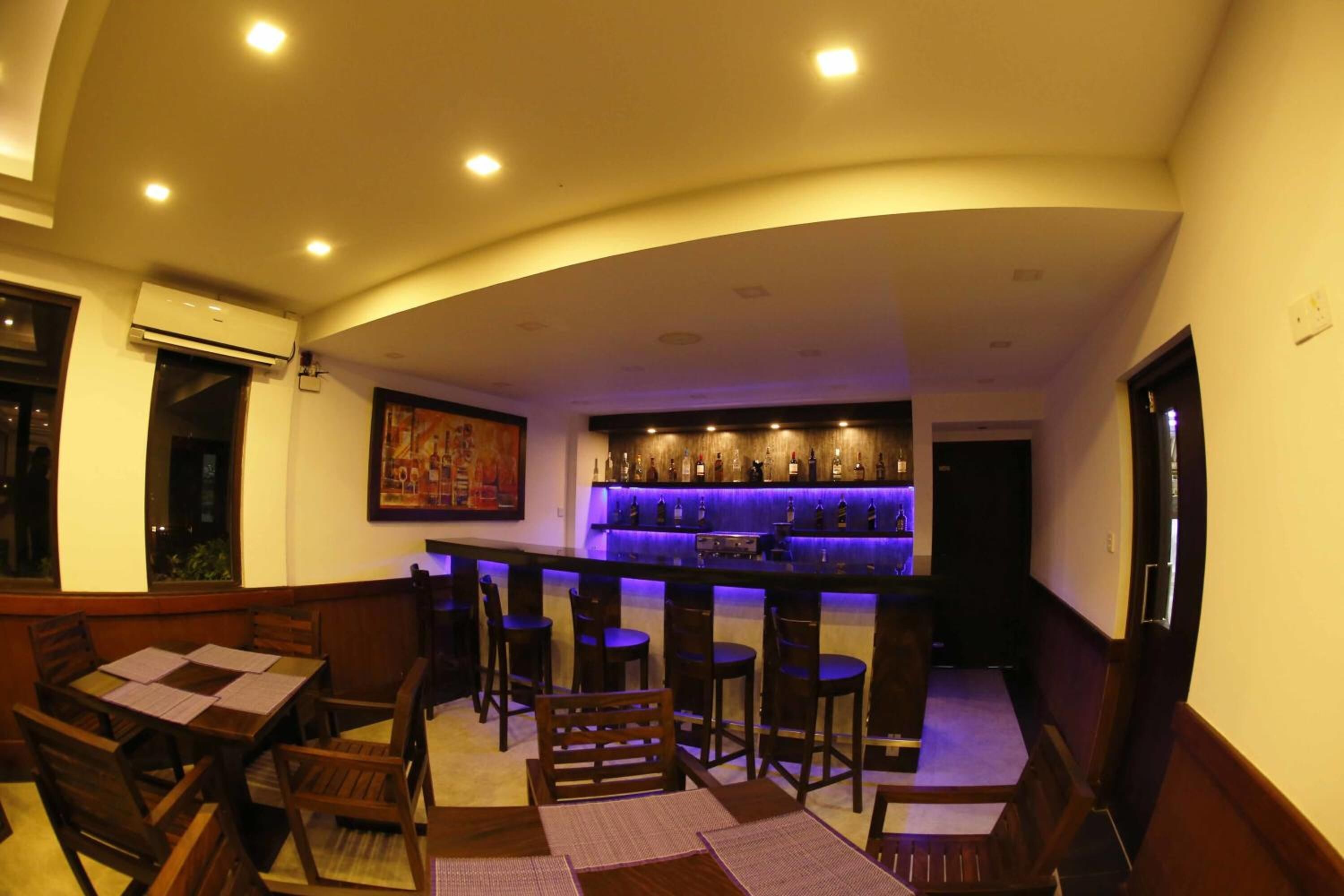 A bar area with wooden furniture and a blue-lit bar counter.