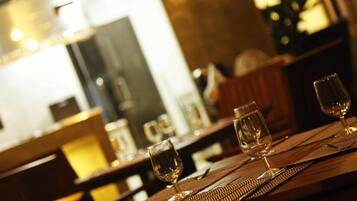 Un ambiente cálido en un restaurante con mesas de madera y copas de vino vacías.
