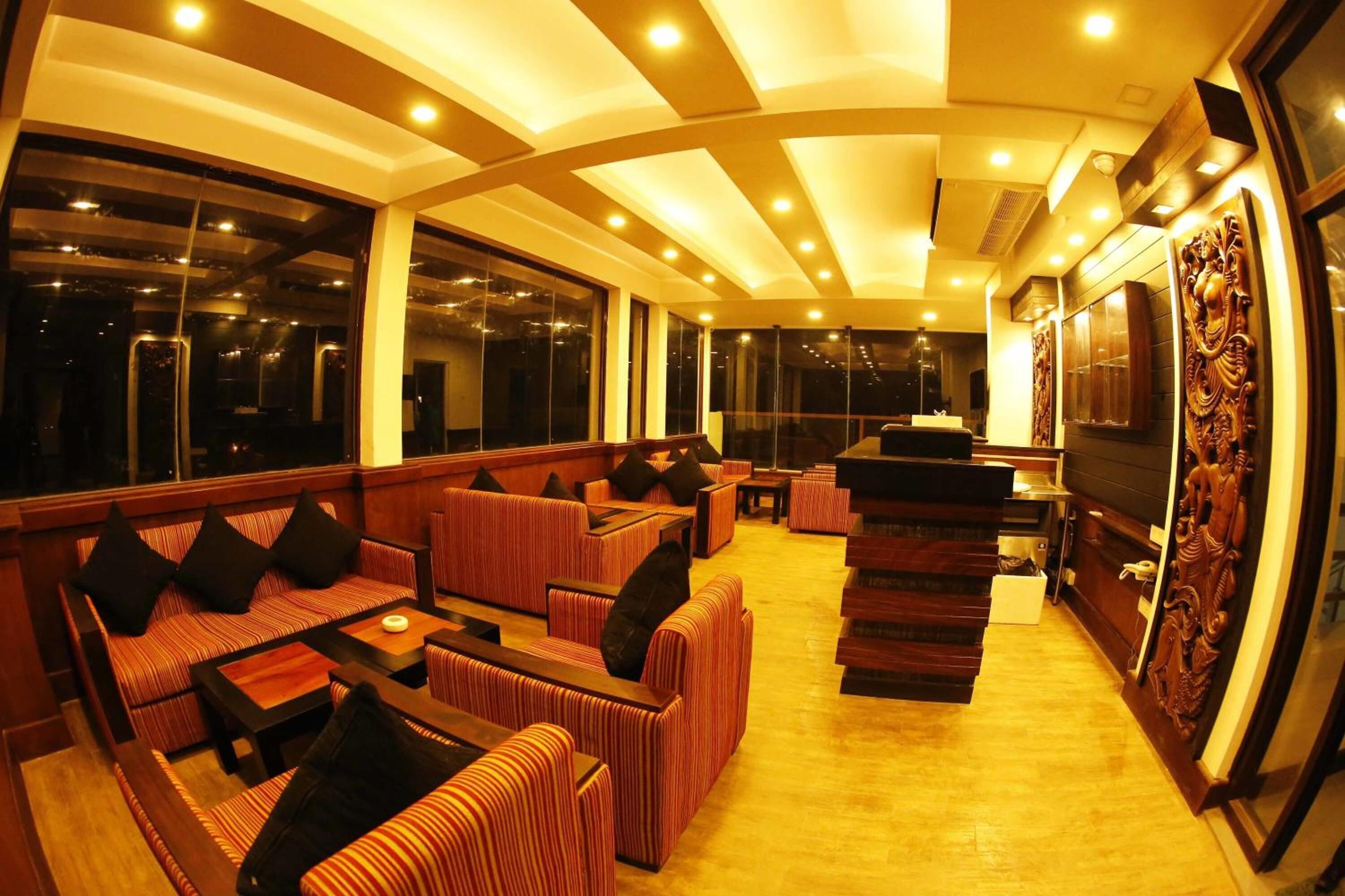 A modern interior with a curved ceiling, large windows, and a seating area with striped sofas and tables.