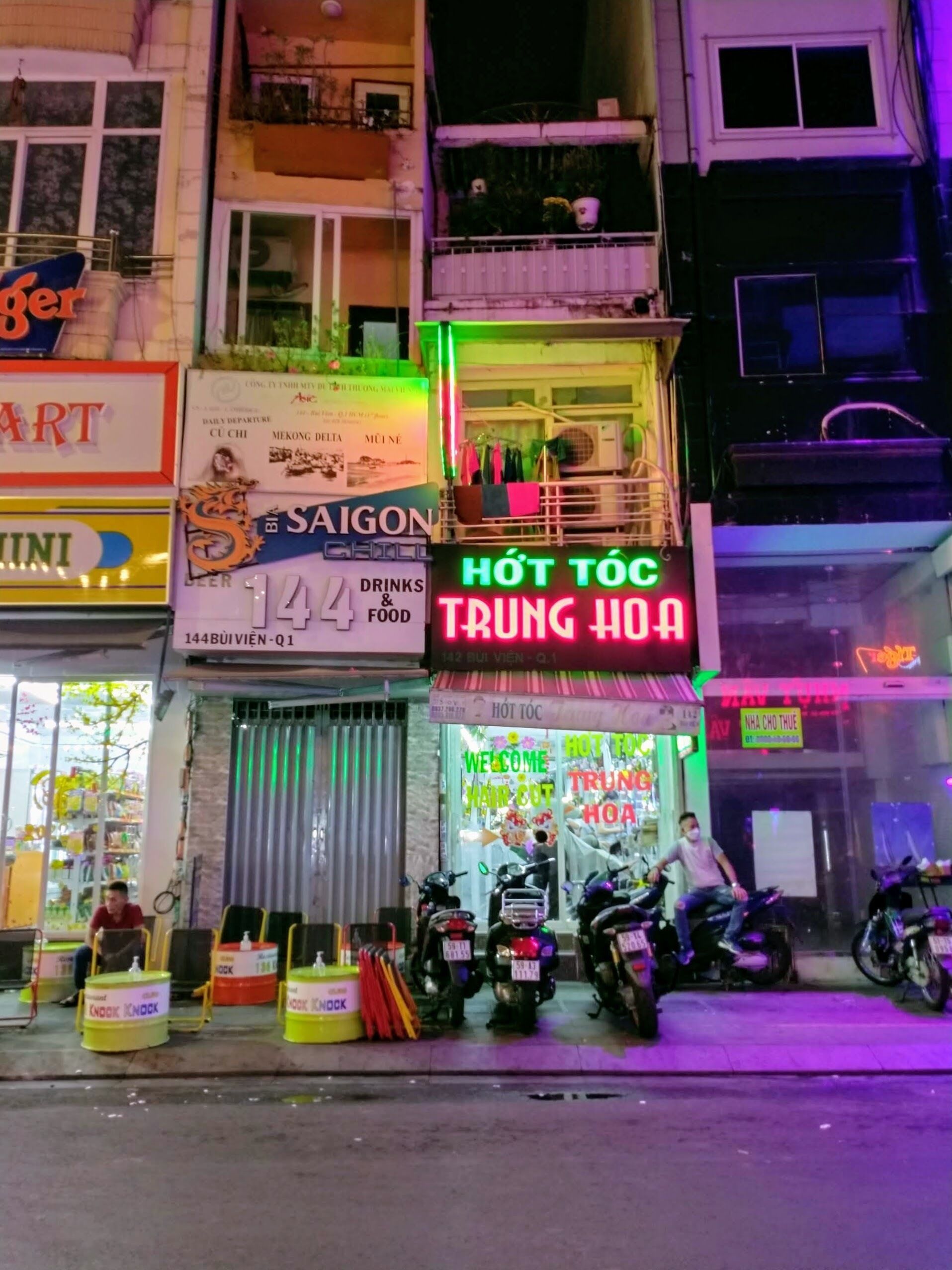 A street view of a building with multiple signs, including 'HÔT TÔC TRUNG HOA' and 'SAIGON'.