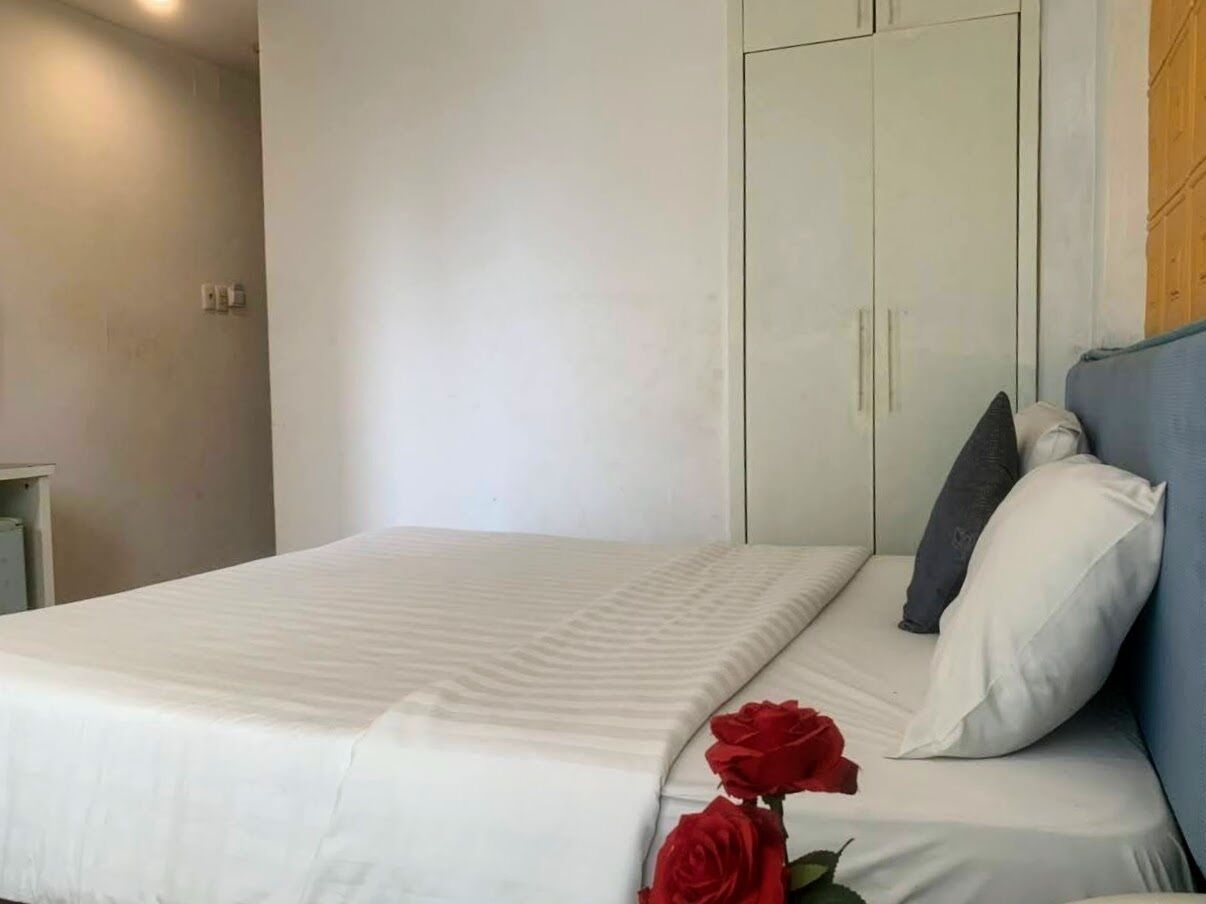 Un dormitorio con cama, armario y mesita de noche.