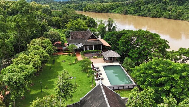 A house with a swimming pool surrounded by lush greenery and a river in the background. - Nam Ou Riverside Hotel & Resort (Pak Ou)