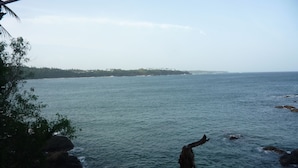 Vista del litoral, amb un terreny rocos i un pal de fusta.
