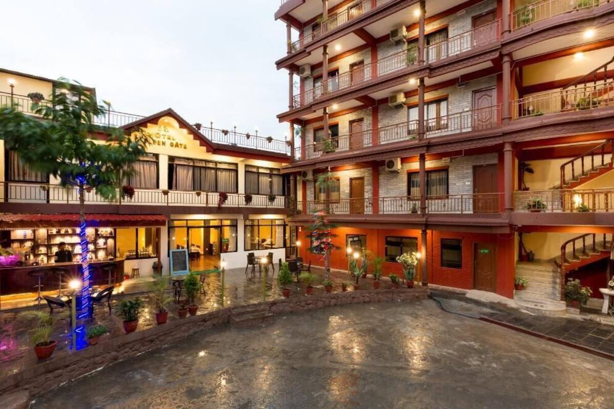 A multi-story hotel with balconies, outdoor seating, and a courtyard.