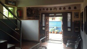 A room with a staircase, a door leading outside, and a small table. - Heart of Bhaktapur (Bhaktapur)