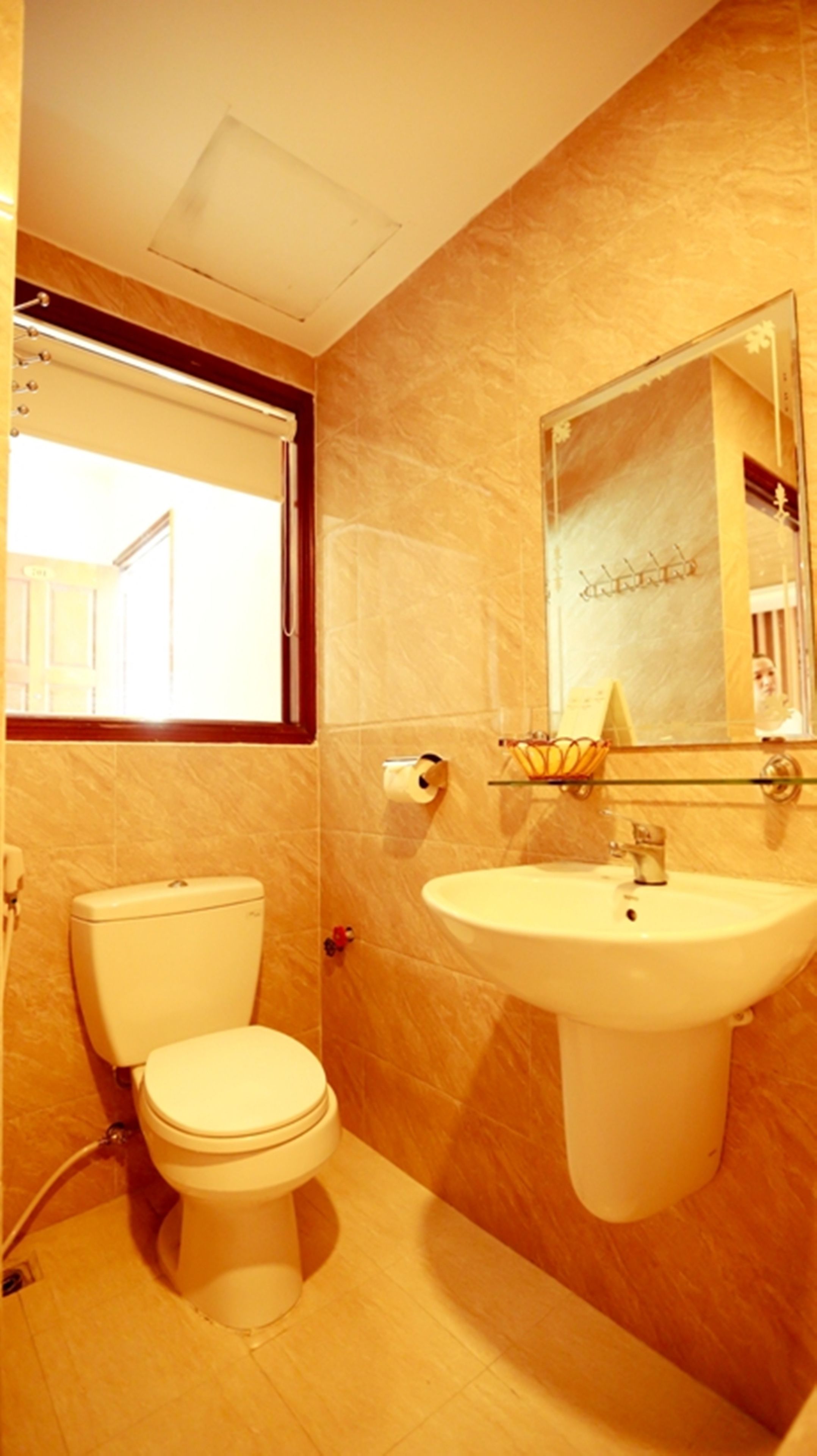 Une salle de bain avec des toilettes, un lavabo et un miroir.