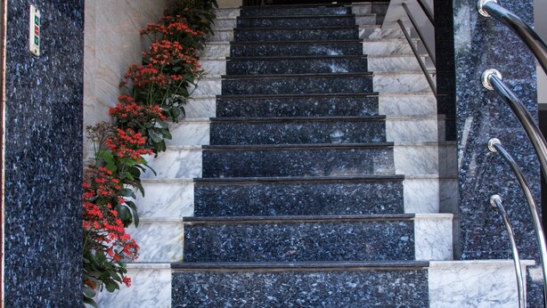 A set of marble stairs with metal handrails, leading to an upper floor. - Xuan Hung Hotel (Da Nang)