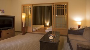 A hotel room with a television, a sofa, a coffee table, and a sliding door with curtains. - Le Beau Max Resort (Fanlu)