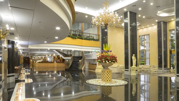 A spacious lobby with a central staircase, a chandelier, and a reception desk. - Le Beau Max Resort (Fanlu)