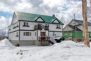 A two-story building with a green roof and a balcony. - Jam Lodge Niseko (Kutchan)