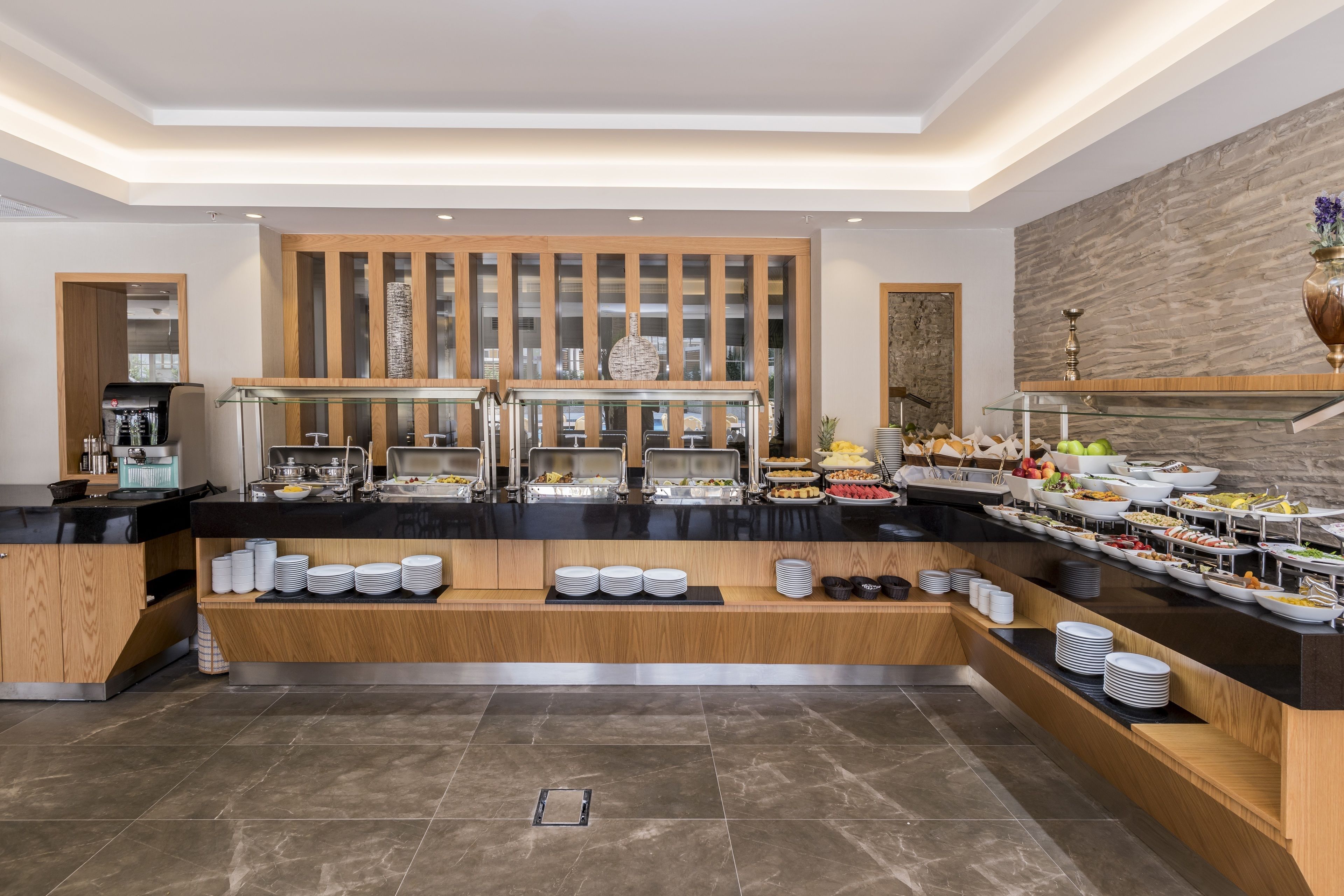 A buffet setup with various food items and a coffee machine.