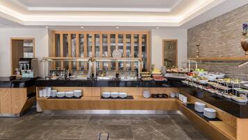 A buffet setup with various food items and a coffee machine.