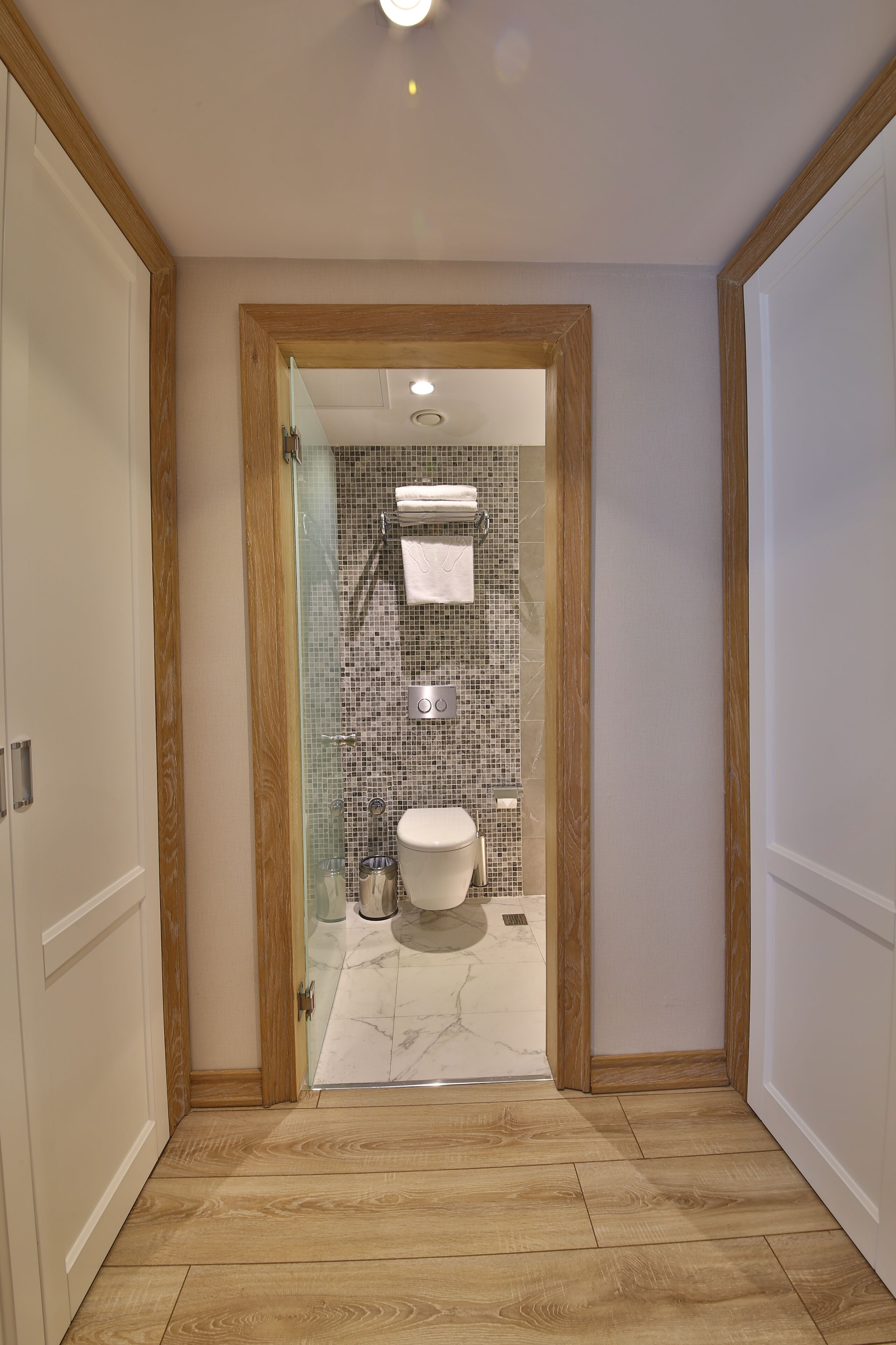 Une salle de bain avec une douche à parois de verre, des toilettes et un mur carrelé.