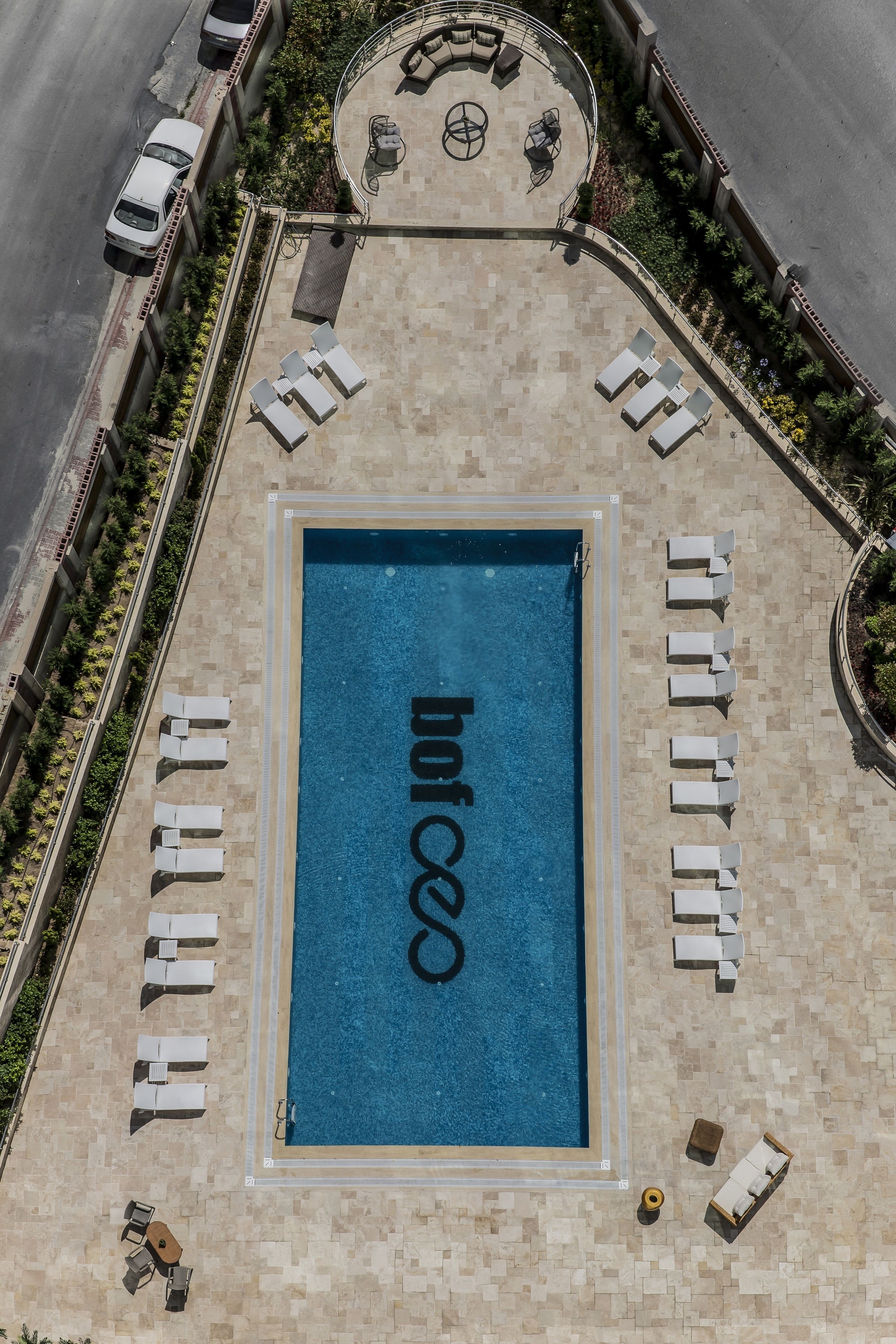 A rooftop pool with lounge chairs and a circular seating area.