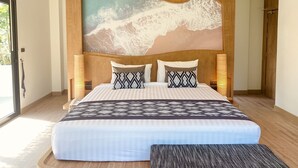 A modern bedroom with a large bed, a wooden headboard, and a large painting of a mountain landscape. - Baan Taranya Koh Yao Yai Resort (Ko Yao)