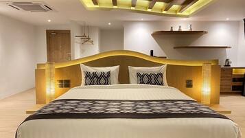 Une chambre à coucher moderne avec un grand lit, une tête de lit en bois et un éclairage intégré.