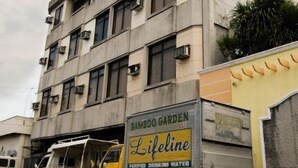 A multi-story building with a commercial truck parked in front. - Bamboo Garden Business Inn (Dipolog)
