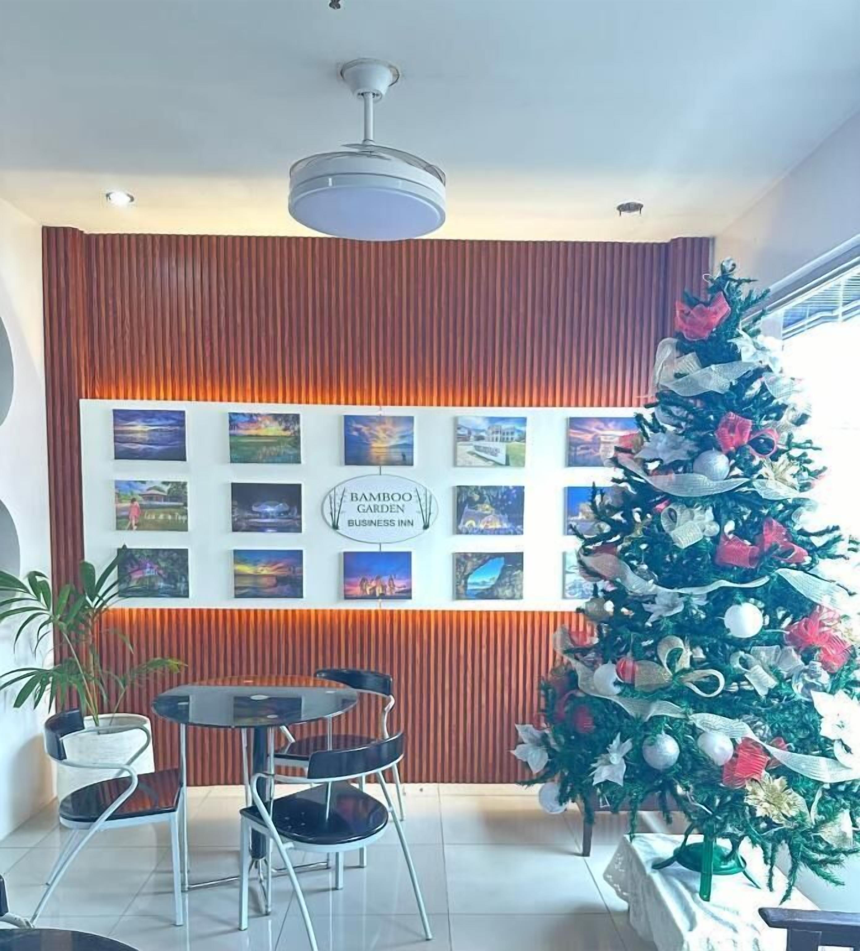 Un interior moderno con una zona de comedor, un árbol de Navidad y una pared con cuadros.