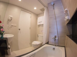 A modern bathroom with a bathtub, toilet, and shower.
