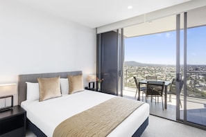 A modern hotel room with a large bed, a desk, and a balcony with a city view. - The Milton Brisbane (Milton)
