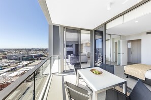A modern apartment with a balcony, a dining area, and a bedroom. - The Milton Brisbane (Milton)