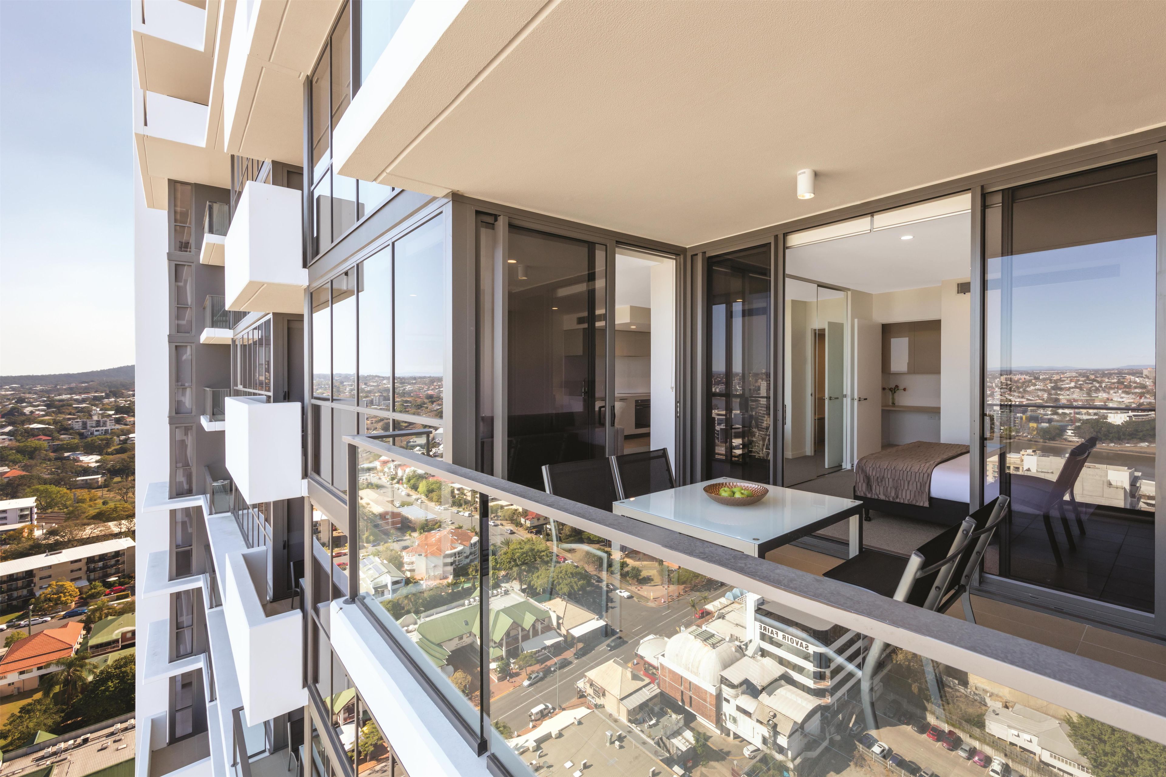 A modern apartment with a balcony overlooking a cityscape.