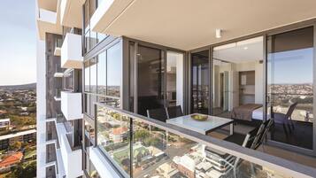A modern apartment with a balcony overlooking a cityscape.