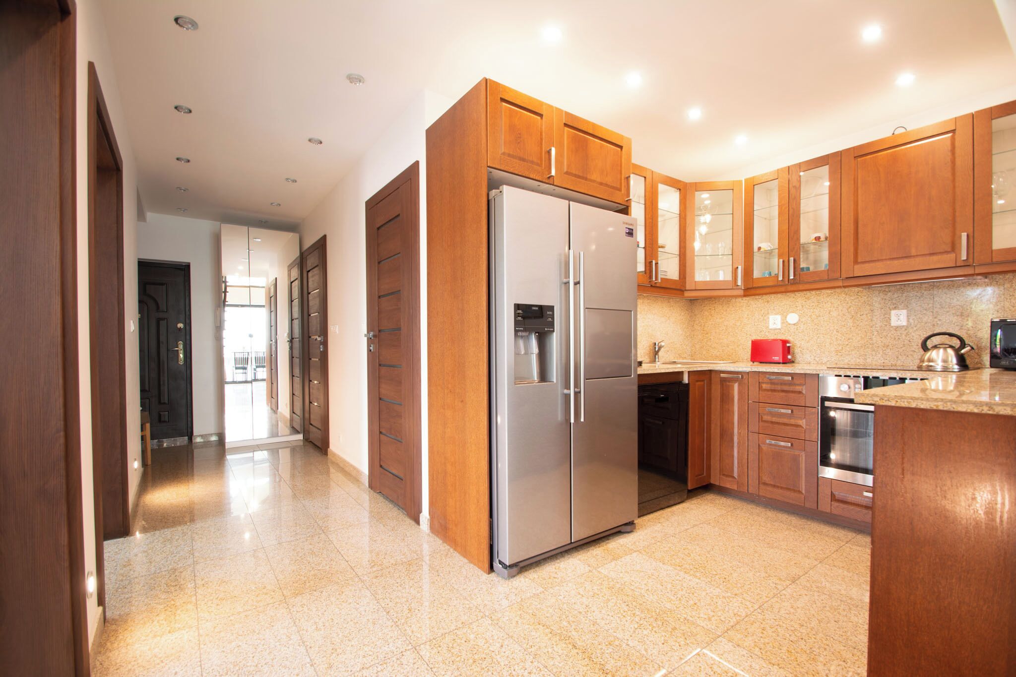 Una cocina moderna con armarios de madera, electrodomésticos de acero inoxidable y encimera de granito.