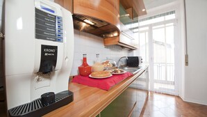 A modern kitchen with a coffee machine, a red mat, and a window with a view. - Verona Maison (Verona)