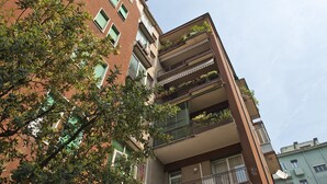 A multi-story building with balconies on each floor, some with plants. - Verona Maison (Verona)