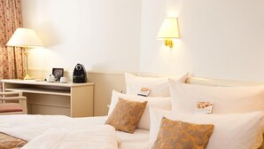 A hotel room with a bed, a desk, and a lamp. - Hoteltraube Rudesheim (Ruedesheim am Rhein)