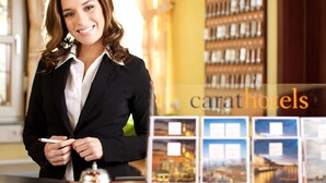 A hotel reception desk with a bell, a pen, and a card holder. There are framed pictures on the wall behind the desk. - Hoteltraube Rudesheim (Ruedesheim am Rhein)