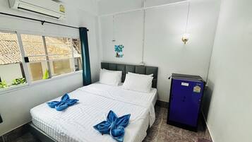Una habitación de hotel con cama, armario y ventana.