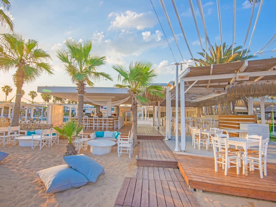 Privat strand, solstolar, parasoller och volleyboll