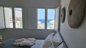 Una habitación con cama, vista al mar y piscina.