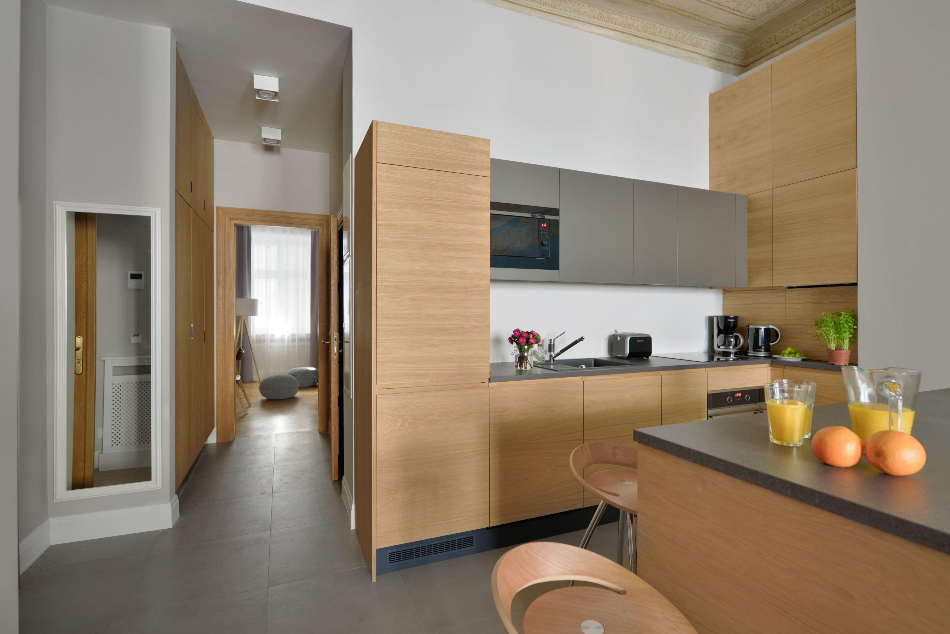 A modern kitchen with wooden cabinets, a built-in oven, and a dining area with a bar.