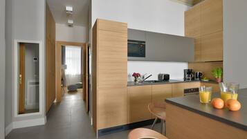 A modern kitchen with wooden cabinets, a built-in oven, and a dining area with a bar.