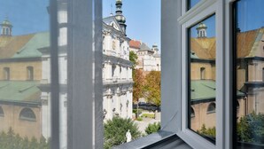 Vista a través de una ventana de un edificio de arquitectura clásica, con cúpula y ventanas en arco.