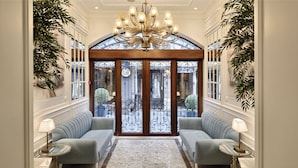 A grand entrance with a chandelier, two sofas, and a patterned rug. - Mirrors Hotel Istanbul Taksim City Center (Istanbul)