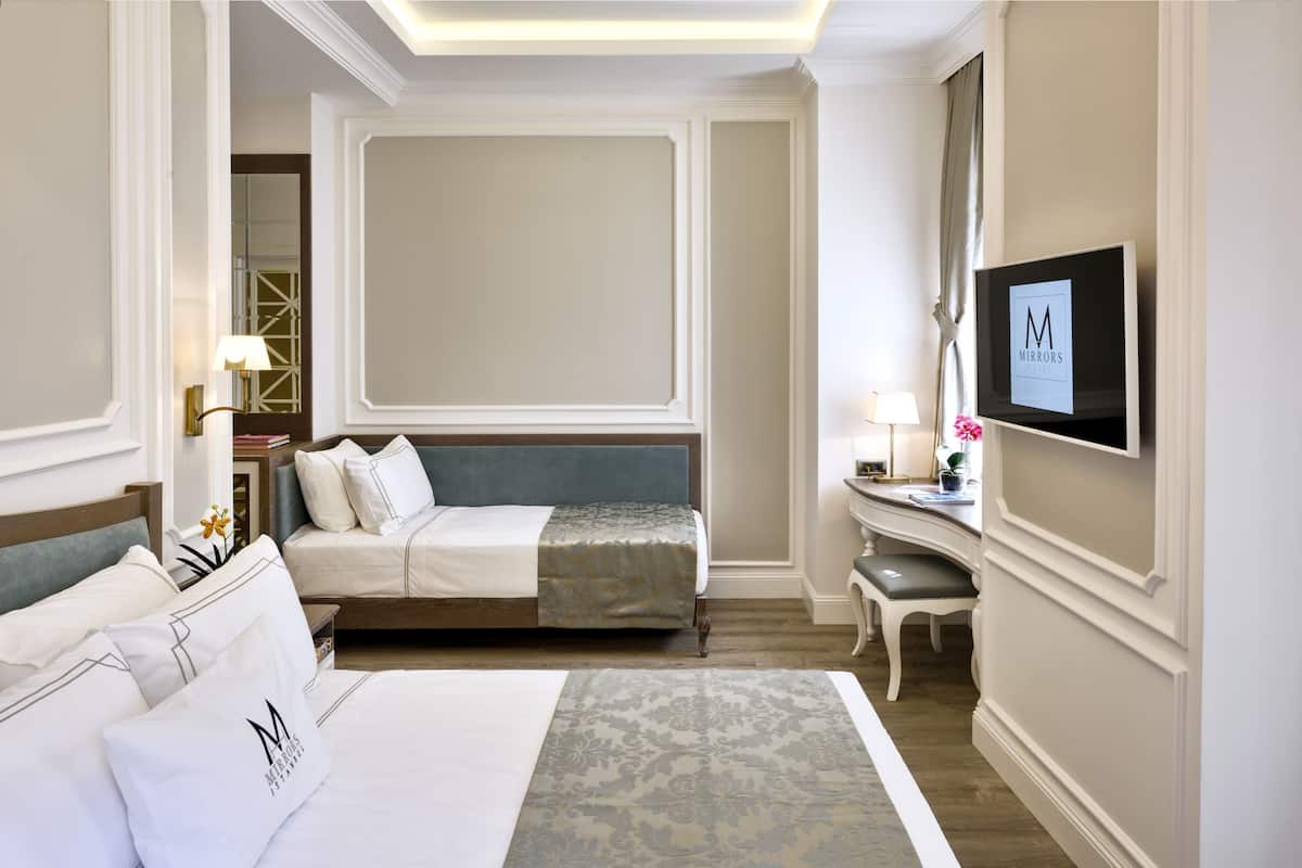 Driepersoonskamer | Luxe beddengoed, een minibar, een kluis op de kamer, een bureau
