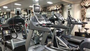 A gym with treadmills, ellipticals, and weight machines. - Addissinia Hotel (Addis Ababa)