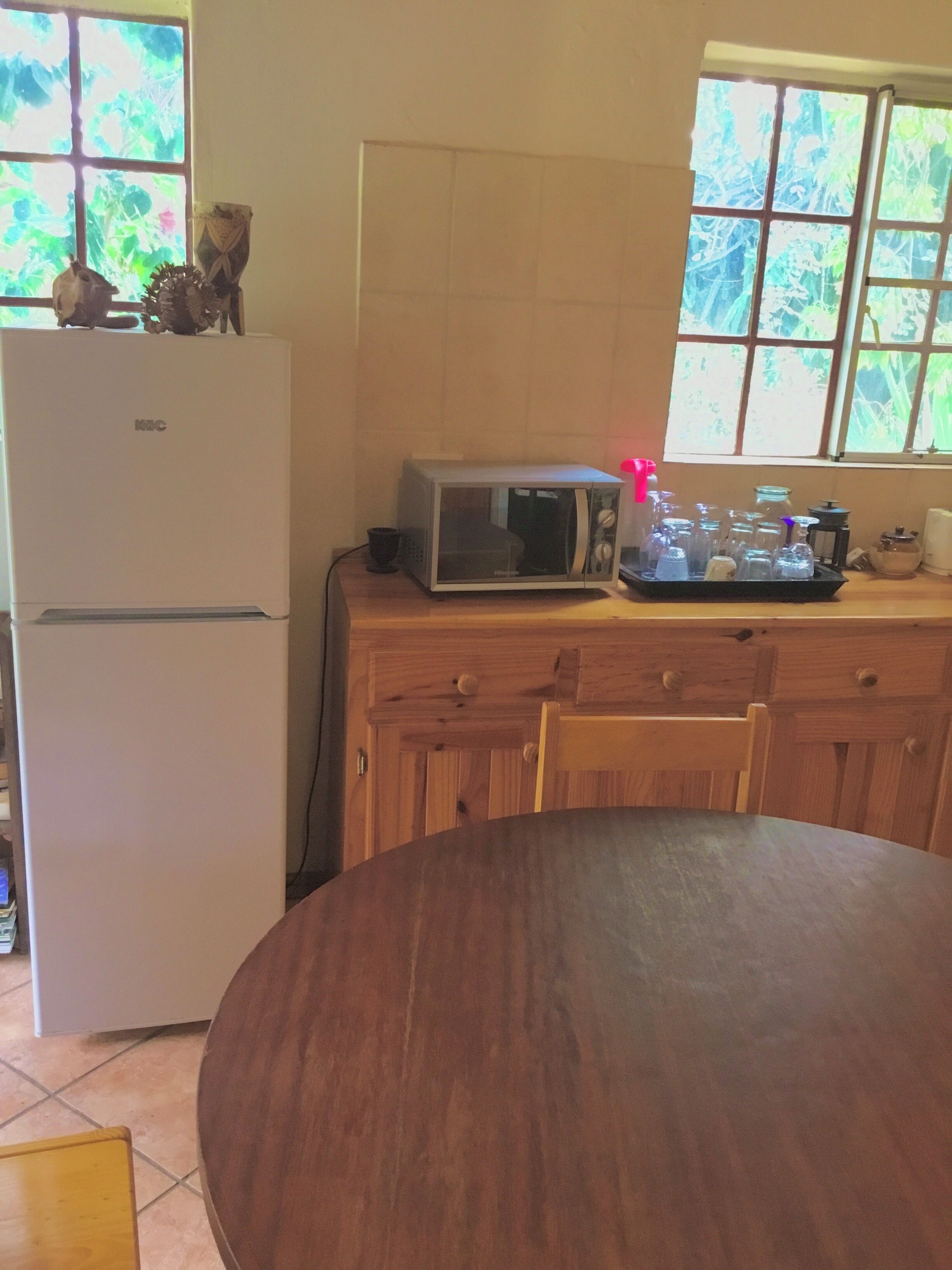 A kitchen with a white refrigerator, a microwave, and a wooden table.