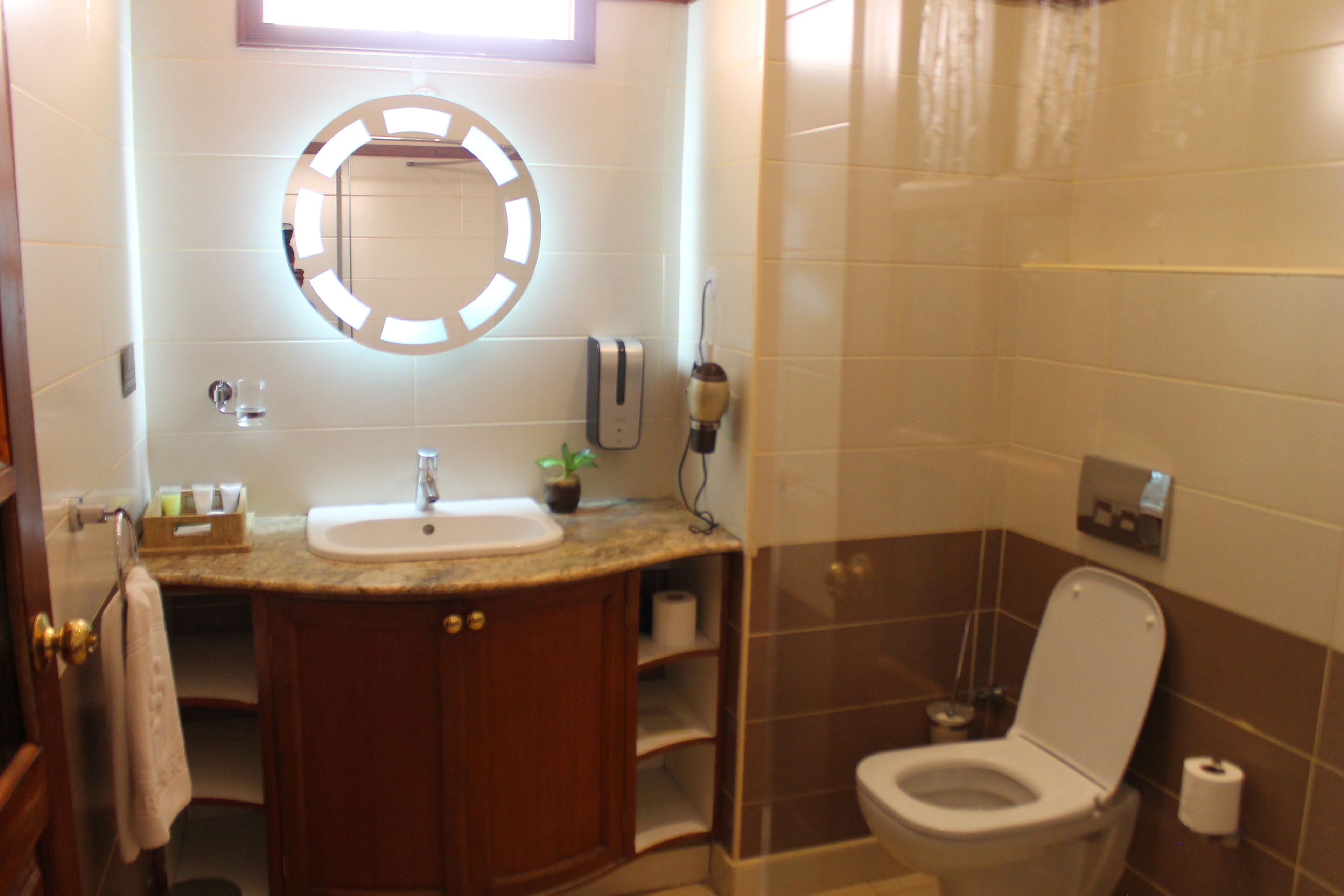A bathroom with a sink, mirror, toilet, and shower.