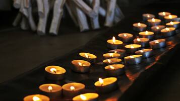 Una hilera de velas encendidas sobre una superficie oscura.