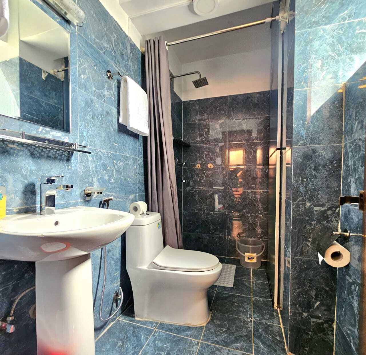 A bathroom with a white sink, toilet, and shower area.